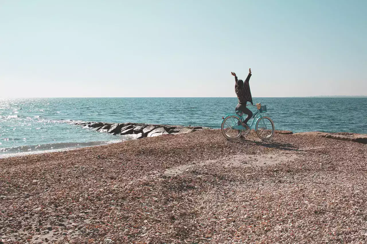 Une cycliste célèbre la joie de la liberté sur un vélo au bord de la mer en fatbike electrique