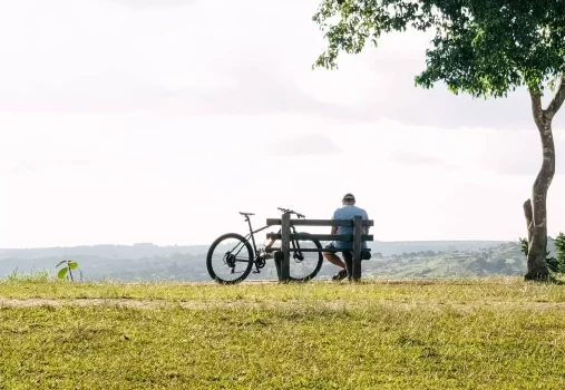 Homme reposant sur un banc à côté de son vélo électrique dans un parc