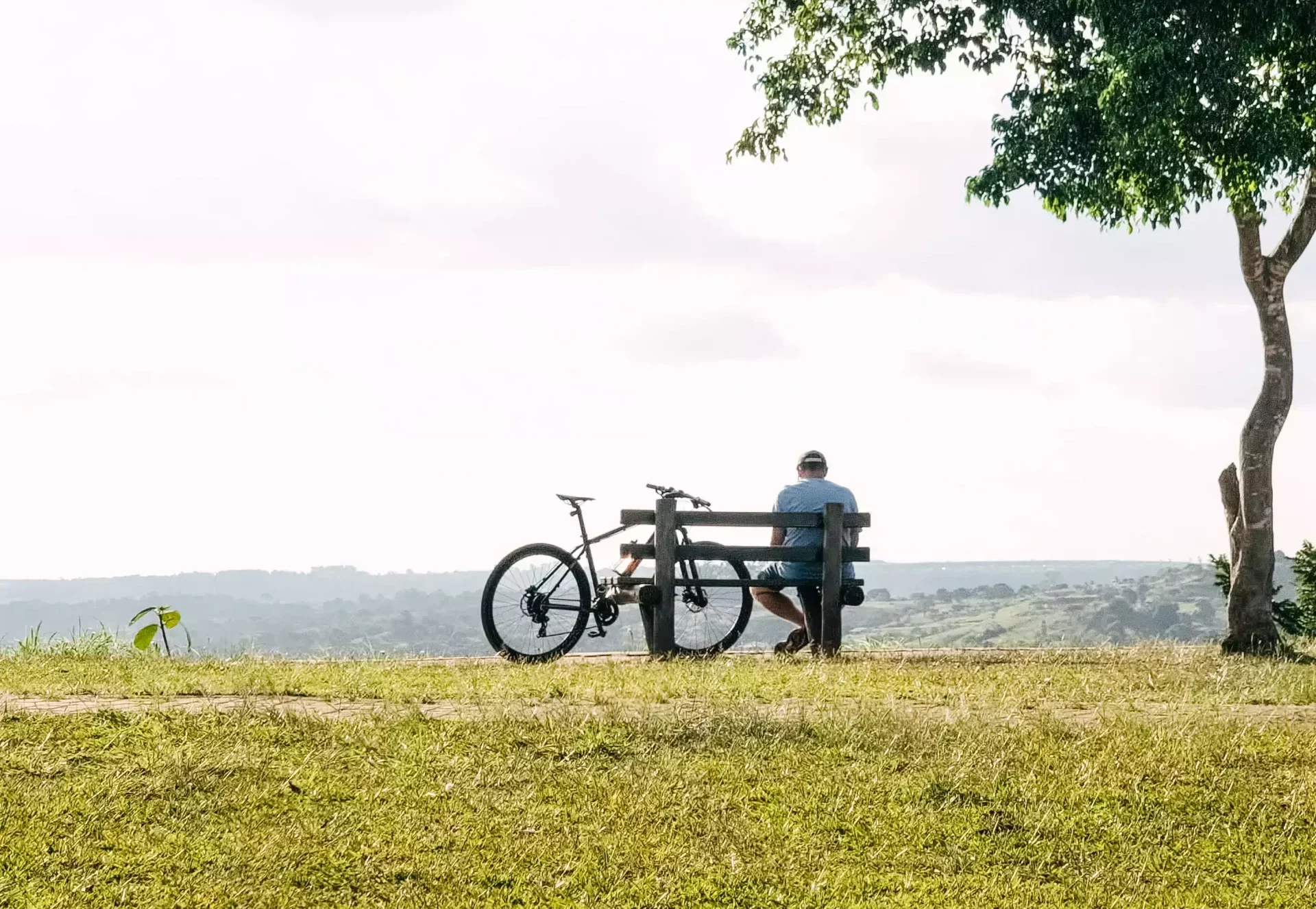 Homme reposant sur un banc à côté de son vélo électrique dans un parc
