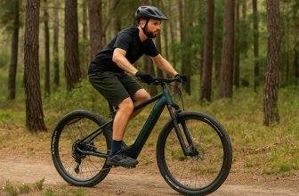 Homme en VTT électrique E-EXPL 700 vert bouteille de Decathlon roulant sur un chemin de forêt